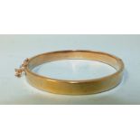 A 9ct gold hinged bangle (small dent), 9.8g.