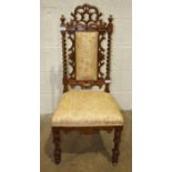 A Victorian walnut framed nursing chair, the carved and padded back with twist supports on