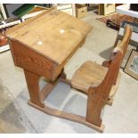 An early 20th century pitch pine and elm school desk and chair, the desk with sloping hinged lid and
