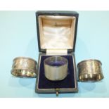 An engine turned silver napkin ring, Birmingham 1977 and two other silver napkin rings, (3).