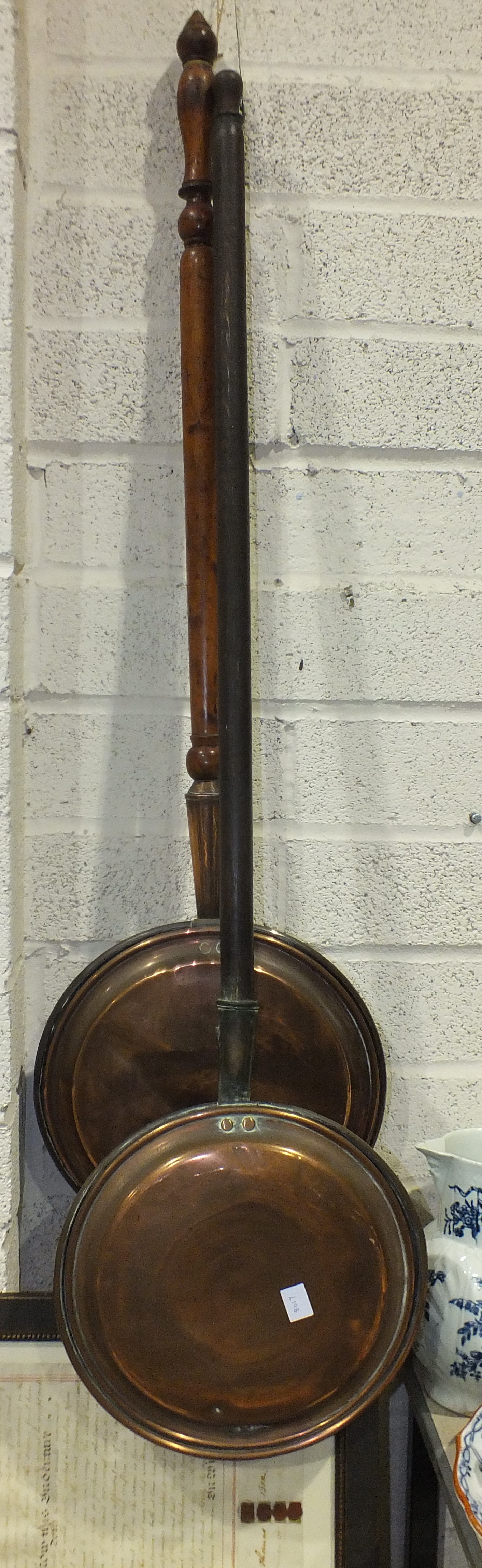 A 19th century copper warming pan with turned fruit wood handle, and another, (2).