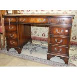 A reproduction mahogany knee-hole writing desk with inset leather top, 123cm wide.