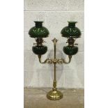 A reproduction student brass double oil lamp with green glass reservoirs and shades, 81cm high