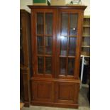 A modern hardwood display cabinet with a pair of glazed doors above two panelled doors, 95cm wide,