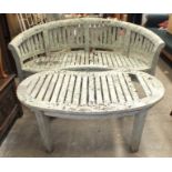 A weathered teak slatted kidney-shaped garden bench, 160cm wide and a matching table, 117 x 56cm.