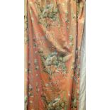 Three chintz design curtains decorated with exotic birds and flowering trees and shrubs, on a salmon
