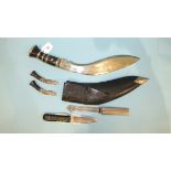 A horn-handled kukri knife in scabbard, with two miniature knives and a sheath knife by George