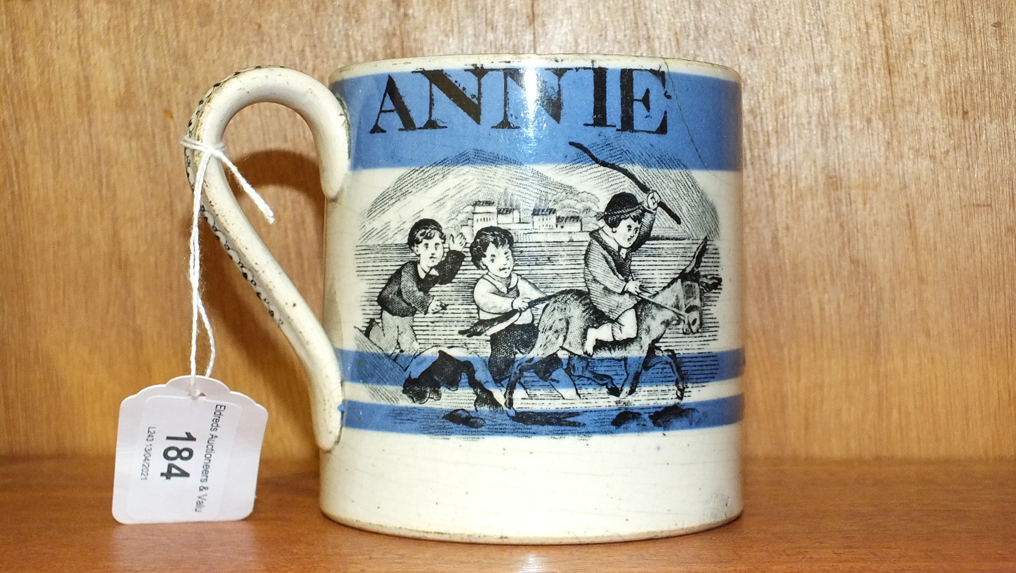 A 19th century Staffordshire mocha ware mug decorated with children playing and with the name 'Annie