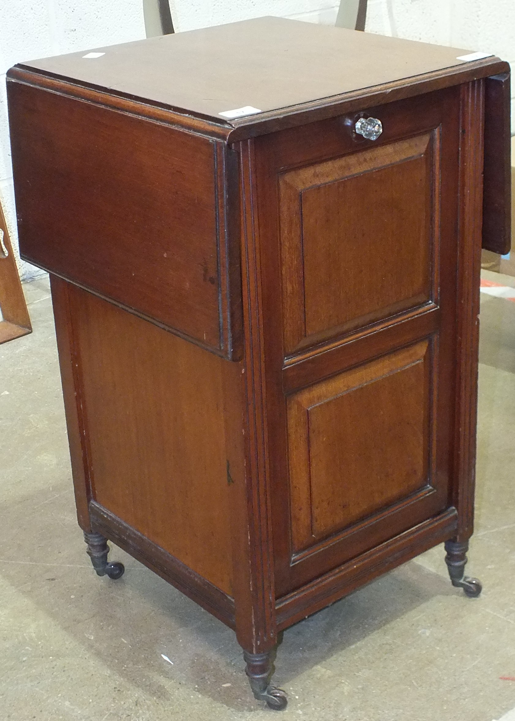 A mahogany coal purdonium with panelled door, wicker lining basket and the top with folding