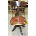 A 1920's oak revolving office chair on quadruped base, (seat torn).