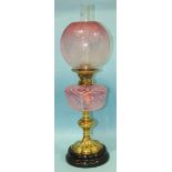 A late-Victorian oil lamp, the brass mount with Duplex wick adjusters, above a pink and opaque