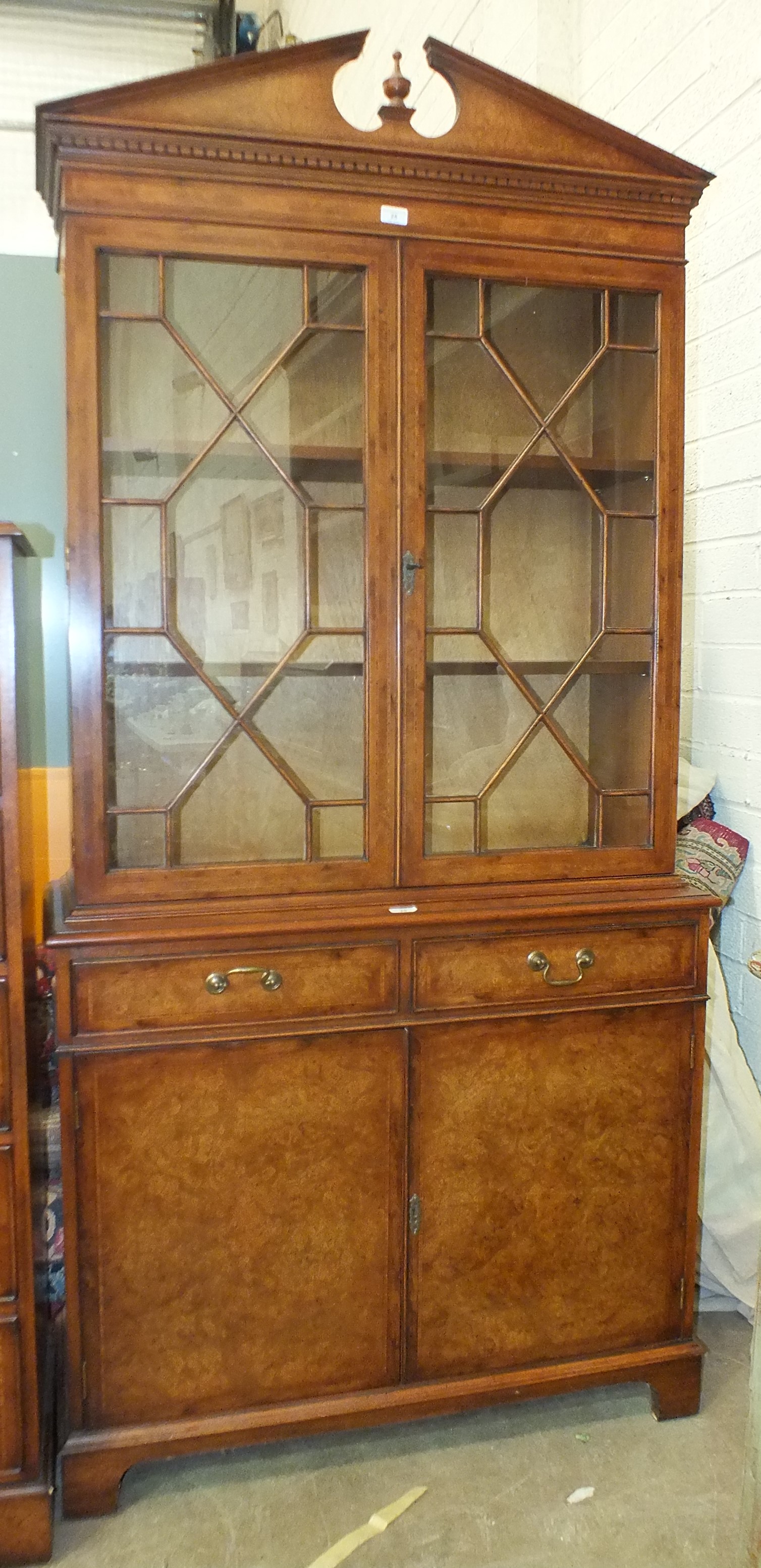 A reproduction walnut cross-banded bookcase in the Georgian taste, having a pair of astragal-