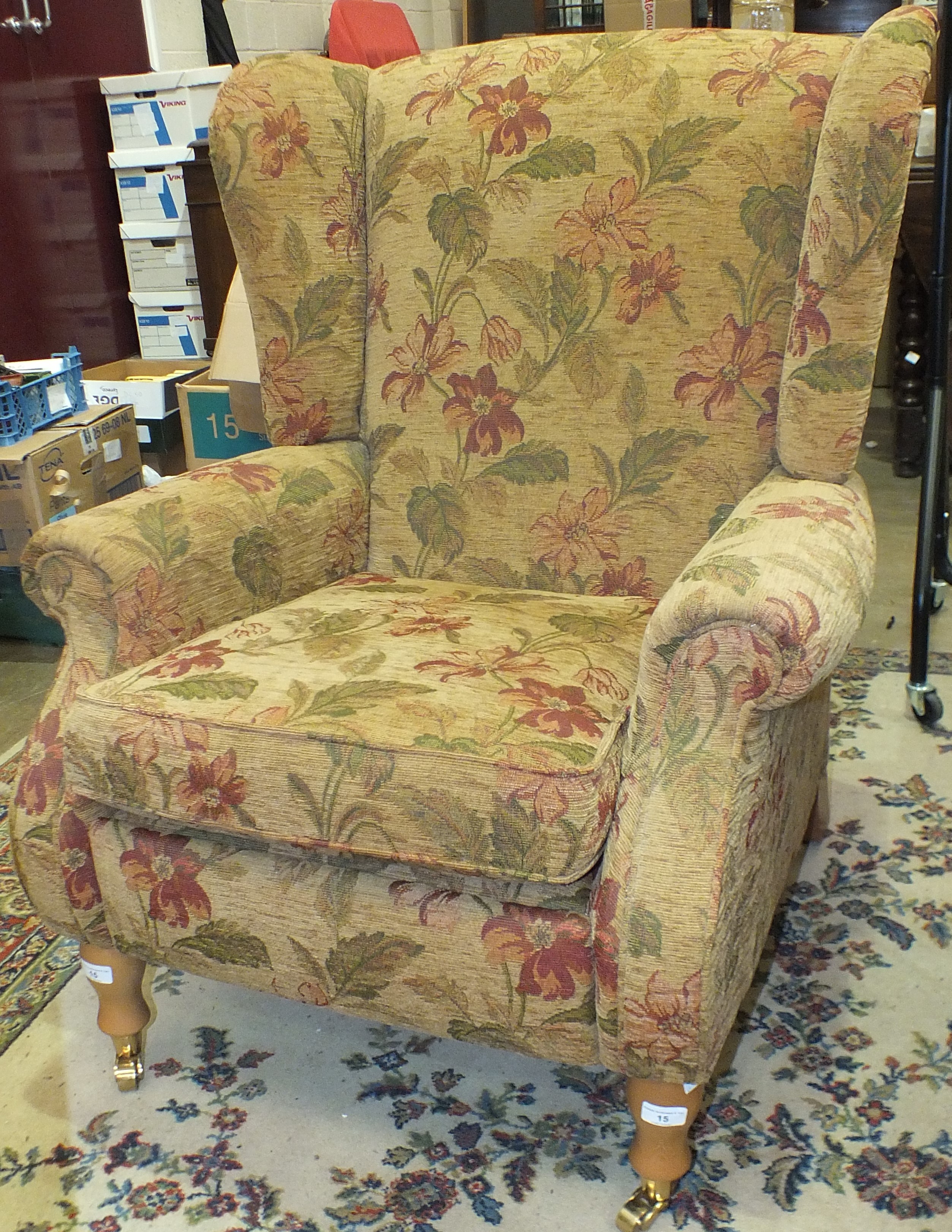 A modern upholstered Parker-Knoll wing armchair, on feet with castors.