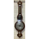 A mahogany wheel barometer with silvered dry/damp thermometer and barometer dials, the spirit