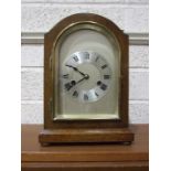An early-20th century oak-cased arched mantel clock, with silvered dial and gong-striking