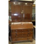 A Georgian mahogany bureau/bookcase, with dentil cornice above a pair of panelled doors with