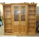 A modern pine breakfront bookcase/cabinet, having a pair of central glazed doors and cupboard doors,