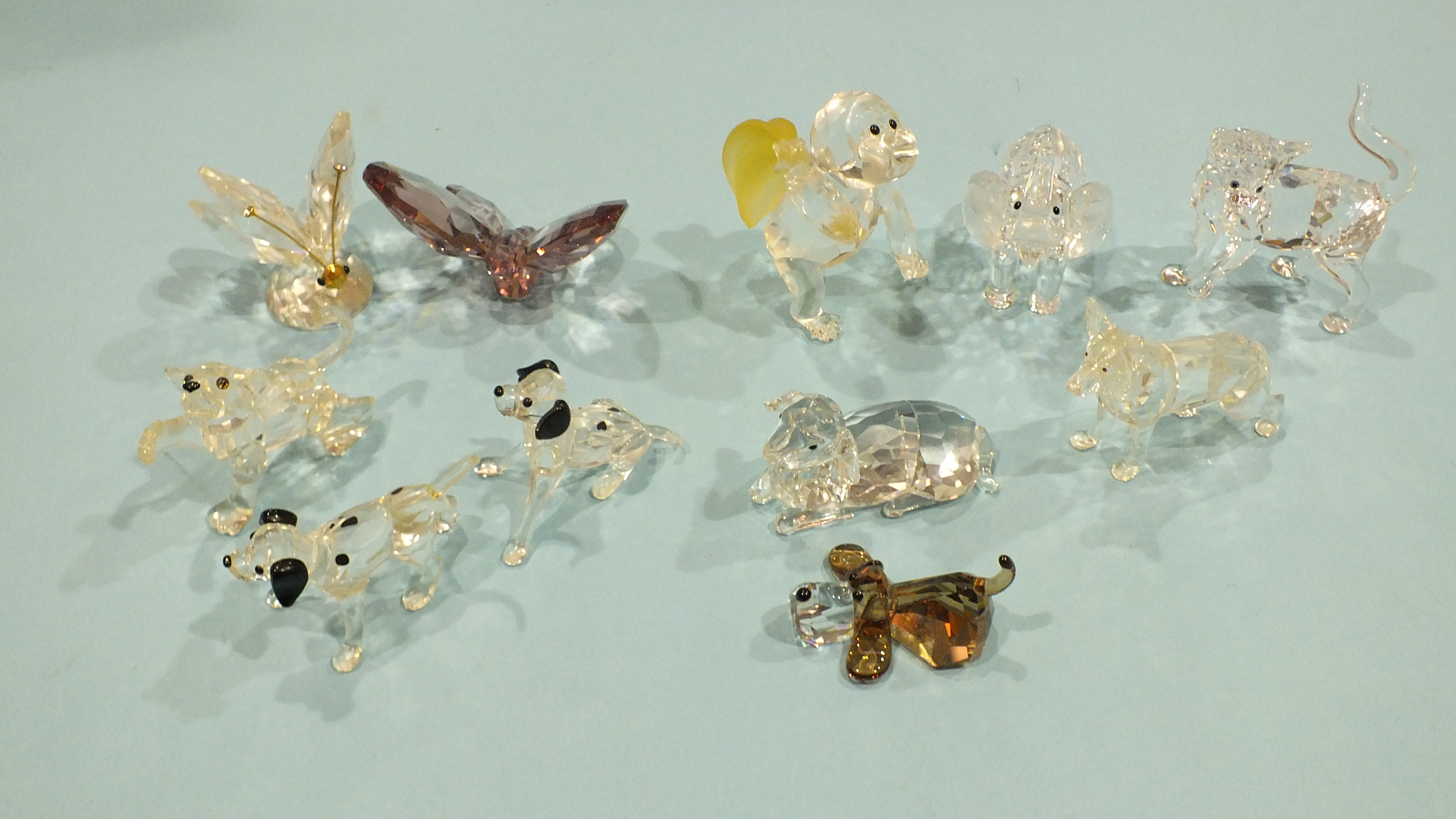 A collection of eleven small Swarovski glass figures: chimpanzee carrying a bunch of bananas,