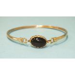 A 9ct gold bangle set black stone, gross weight 6.1g.