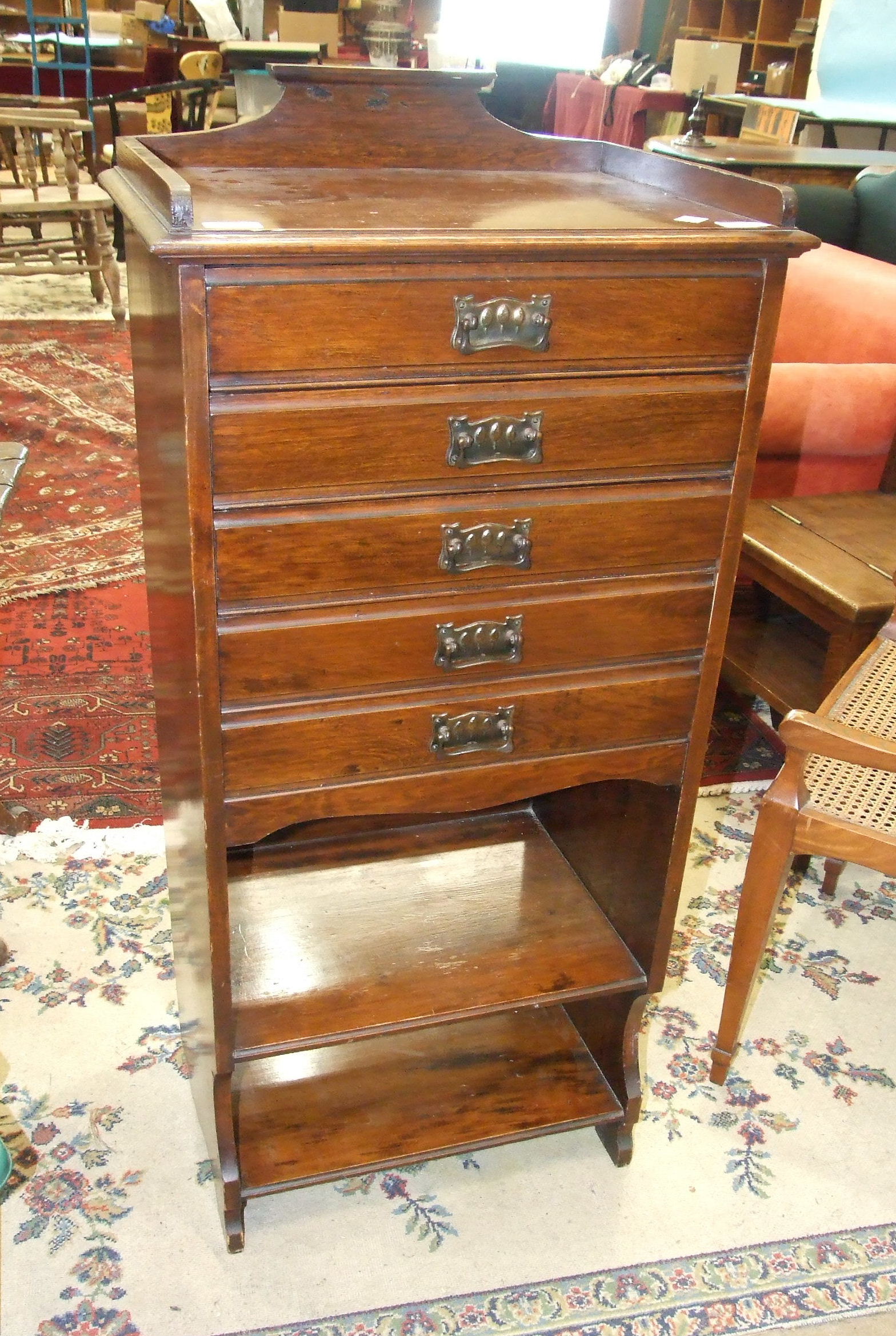 An Edwardian stained wood music cabinet of five drop-down doors above two shelves, 50cm wide,