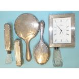 An Italian silver-framed battery clock, a silver-backed dressing table set, Birmingham 1921 and