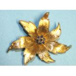 A 1960's 18ct gold brooch of floral form, centrally-set a cluster of seven round-cut sapphires,