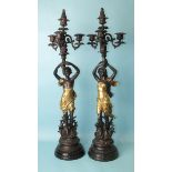 After Emile Bruchon, a pair of reproduction bronzed metal figural candelabras, a male and a female