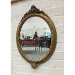 A Victorian oval gilt gesso wall mirror with beaded and foliate scrolling frame, 85cm high, 58cm