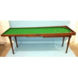 An early-19th century mahogany bagatelle table, the folding top and baize lined interior with