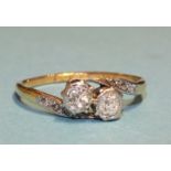 A diamond cross-over ring set two old brilliant-cut diamonds, between diamond-set shoulders, the