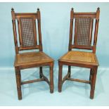 A pair of Gothic-style oak hall chairs, each chamfered frame with caned back and seat (2).