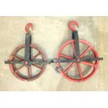 A large cast iron pulley wheel, 55cm diameter and a smaller pulley wheel, 48cm diameter, (2).