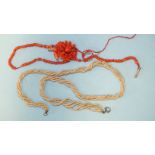 A necklace of six twisted strands of seed pearls, 38cm long, a coral pendant of floral form, (one
