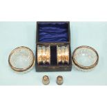 A pair of cased silver napkin rings, Birmingham 1910, a pair of silver-mounted glass salts, a silver