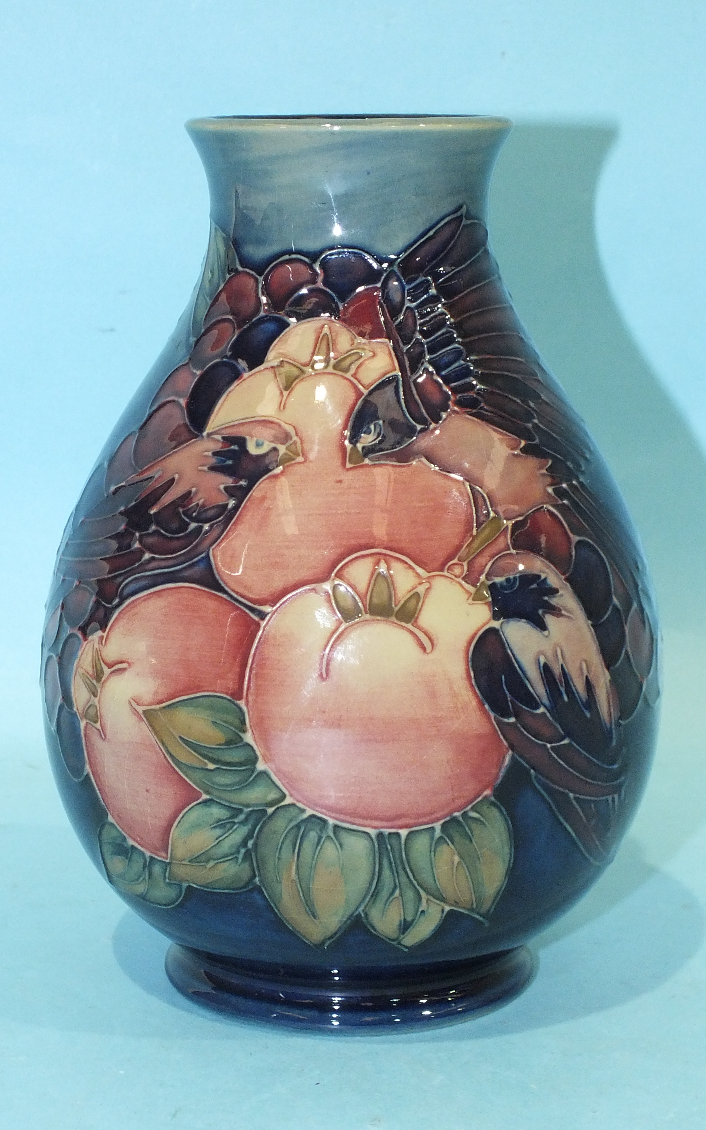 A modern Moorcroft baluster-shaped vase with pomegranate, berries and birds tubelined decoration,