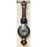 A mahogany wheel barometer with silvered dry/damp thermometer and barometer dials, the spirit