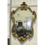 A modern gilt scrolling frame wall mirror, 98 x 63cm, a wool-work picture and an oleograph