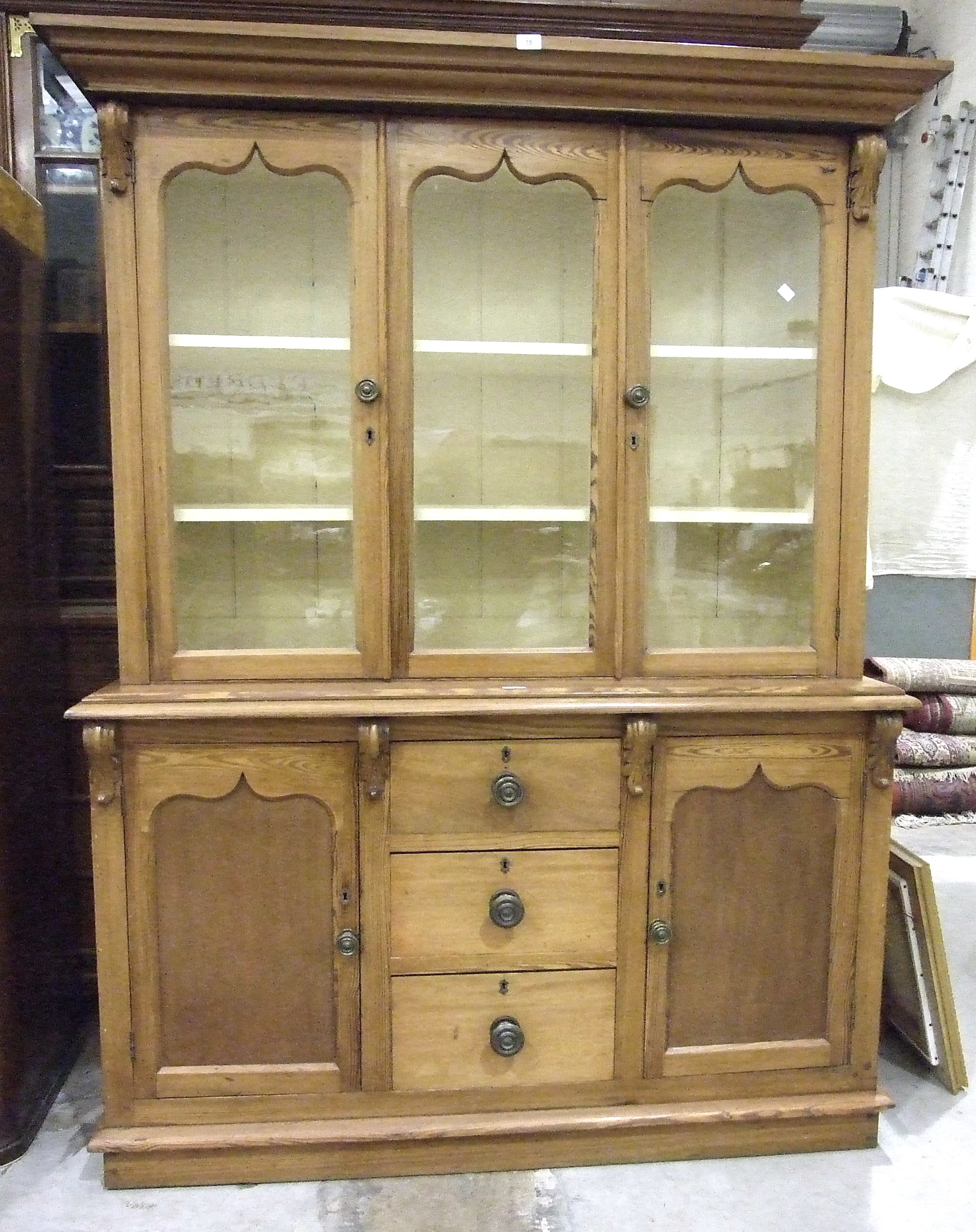 A Victorian pitch pine dresser, the moulded cornice above three glazed doors, the lower part with