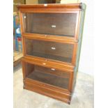 A Globe Wernicke mahogany three-tier bookcase, with glazed up-and-over doors, (one unglazed), on