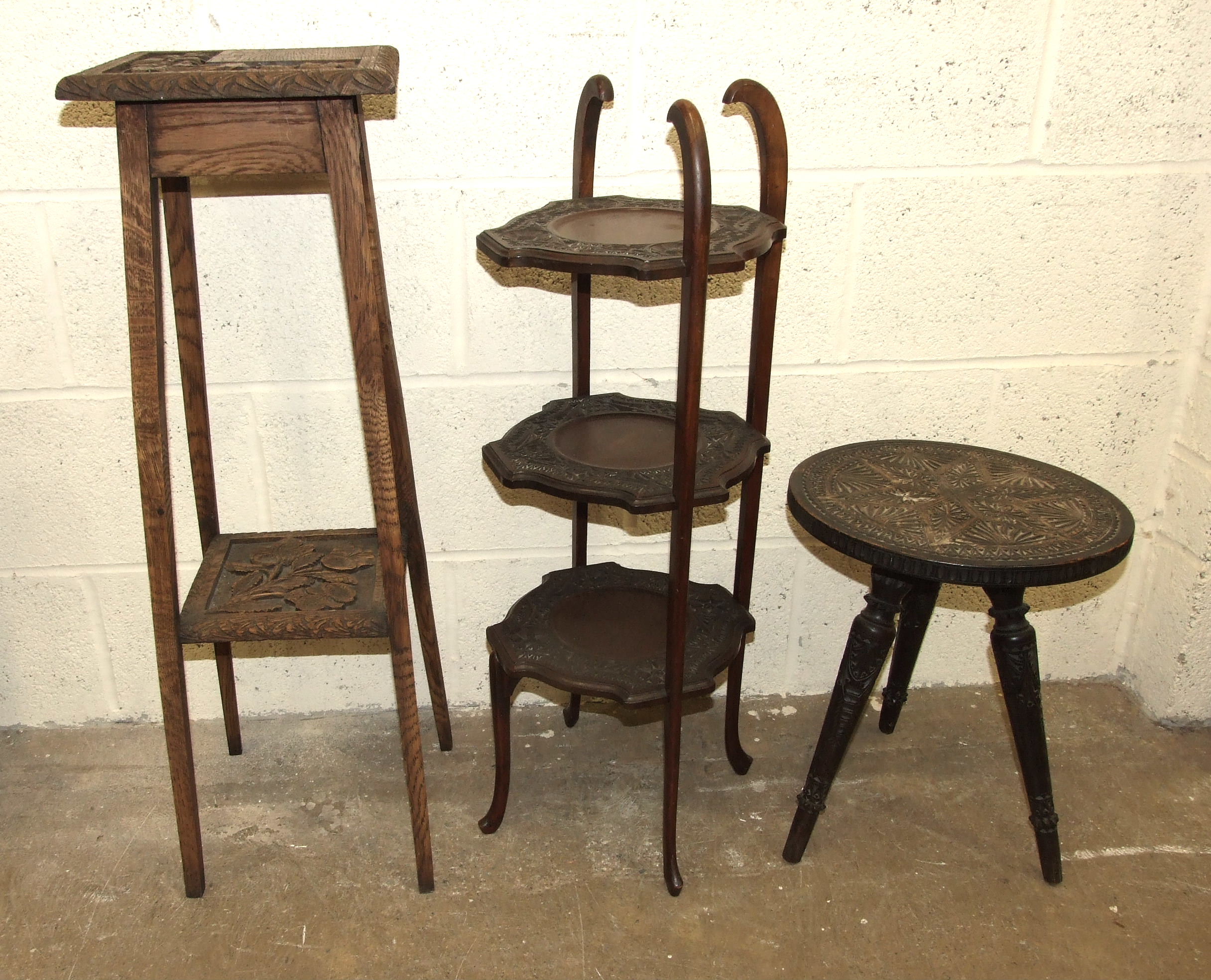 A carved wood three-legged table, a three-tier cake stand and a plant stand, (3).