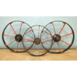 A pair of iron spoked cart wheels, 72cm diameter and a smaller iron spoked wheel, 63cm diameter, (