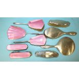 A 1930's silver and pink enamel backed five-piece dressing table set, comprising hand mirror, two