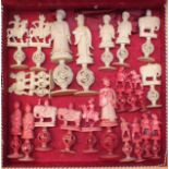 A part set of late 19th century Chinese carved natural and red-stained ivory chess pieces on