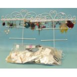 A large quantity of earrings (for pierced ears) on retailers' cards and two wire display racks for