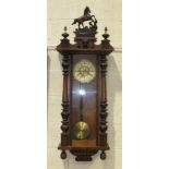 A late-19th century wood-cased striking Vienna-style wall clock, the pediment with a carved horse,