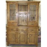 A modern stained pine dresser, the upper section fitted with a pair of glazed doors and four drawers