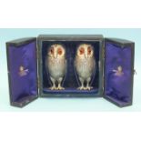 A pair of Victorian novelty silver peppers in the form of standing owls, with glass eyes, feather