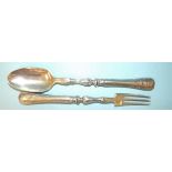 A pair of silver salad servers with silver spoon bowl and fork tines and beaded filled handles,