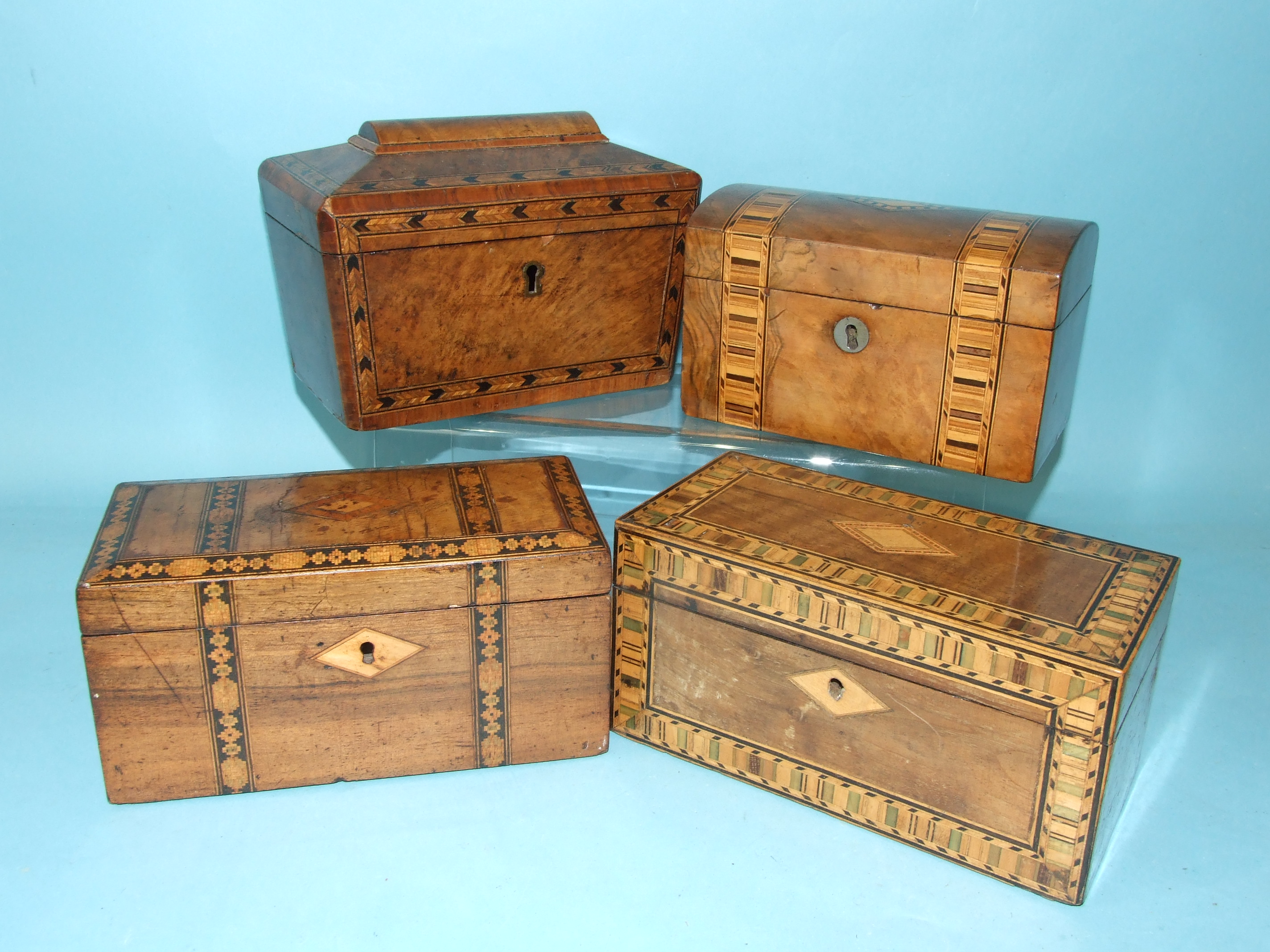 An oblong walnut tea caddy with bands of Tunbridge ware decoration, 20cm wide and three other inlaid