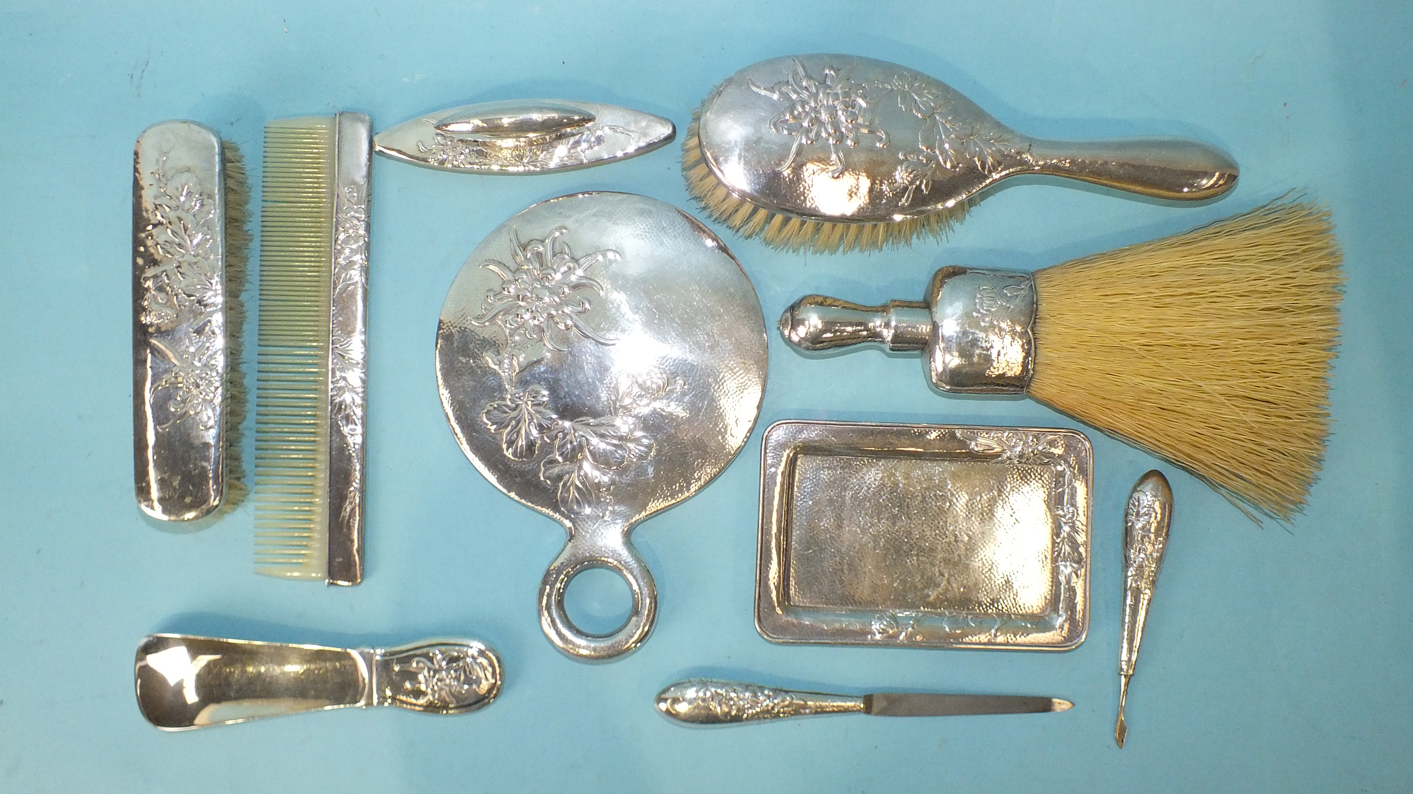 An early-20th century silver-backed dressing table set and manicure set, including circular hand